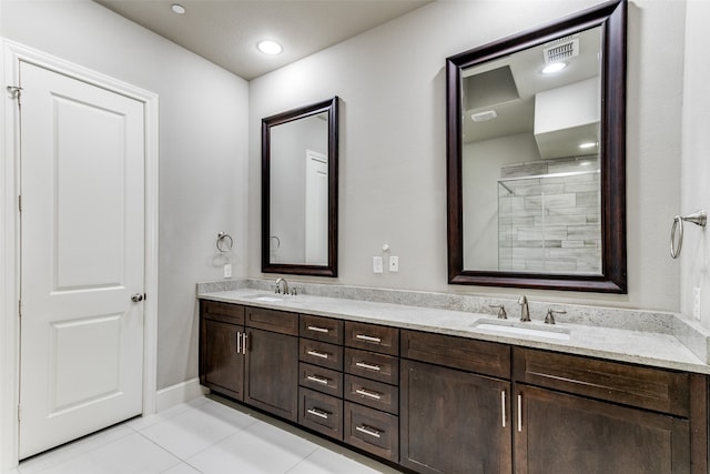 bathroom with tile flooring, oversized vanity, and dual sinks