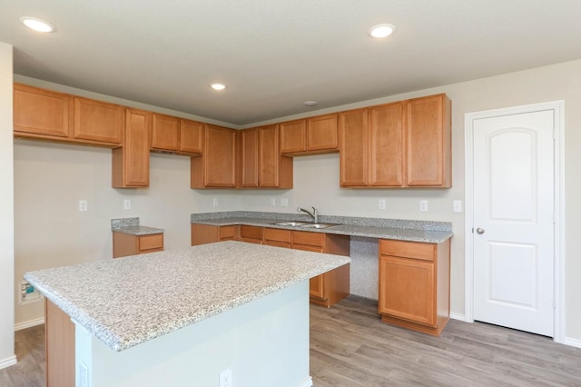 kitchen with sink, light hardwood / wood-style floors, and a center island