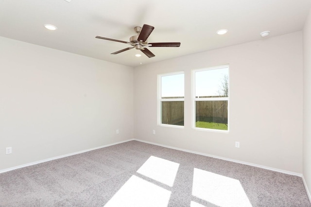 unfurnished room with light colored carpet and ceiling fan