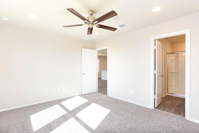 unfurnished bedroom with ceiling fan, connected bathroom, and carpet