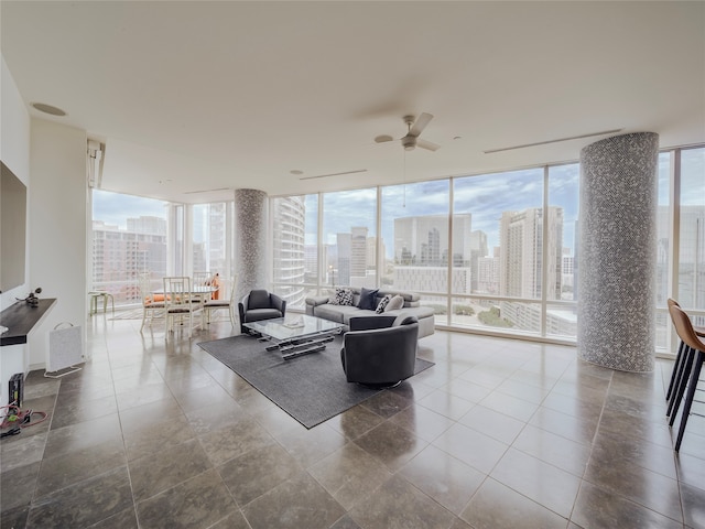 living room featuring a wall of windows, a healthy amount of sunlight, and ceiling fan