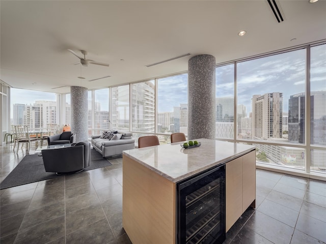 kitchen with plenty of natural light, floor to ceiling windows, a kitchen island, and wine cooler