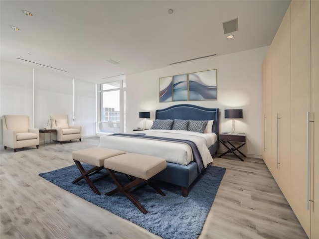 bedroom featuring light hardwood / wood-style floors and expansive windows