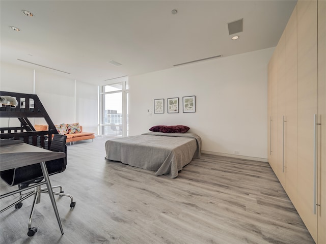 bedroom with light hardwood / wood-style flooring and floor to ceiling windows