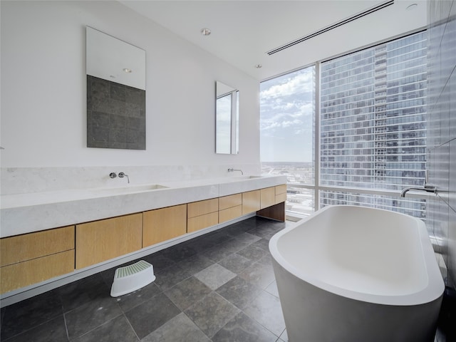 bathroom with vanity, a bathtub, and expansive windows