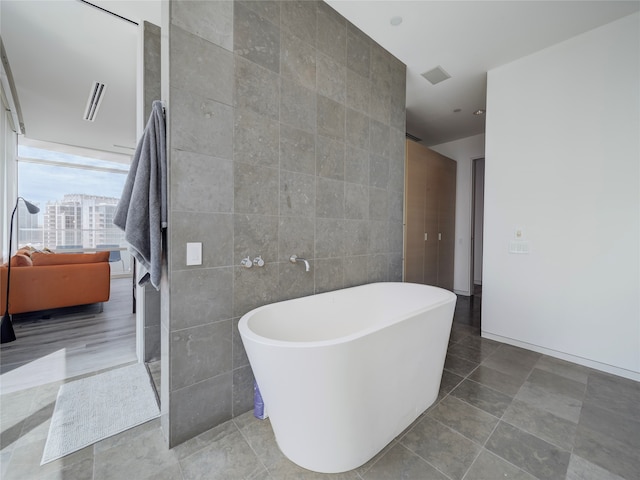 bathroom featuring tile walls and a tub