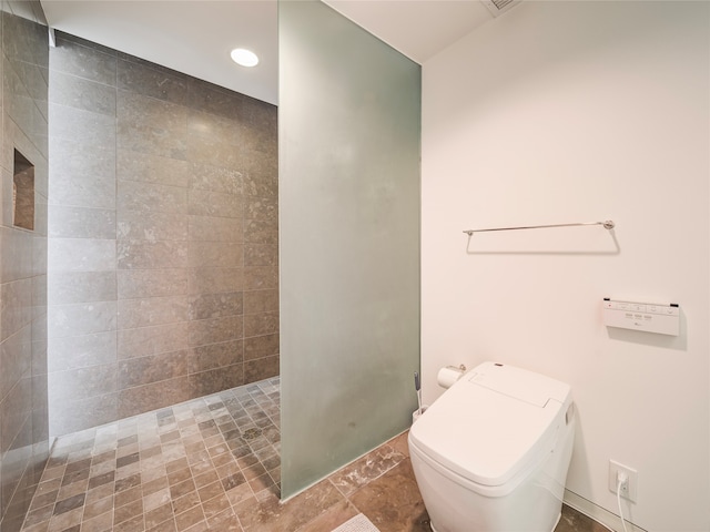 bathroom featuring tile patterned floors, toilet, and walk in shower