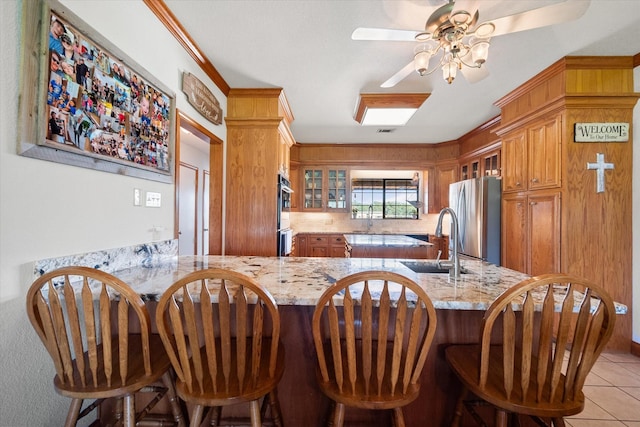 kitchen featuring light stone counters, kitchen peninsula, and stainless steel appliances