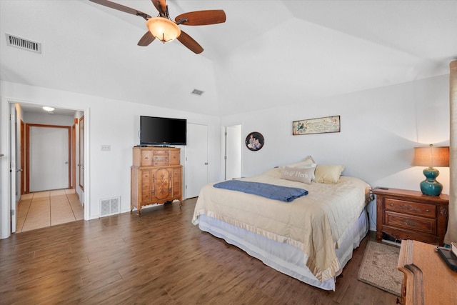 bedroom with ceiling fan, hardwood / wood-style floors, and vaulted ceiling