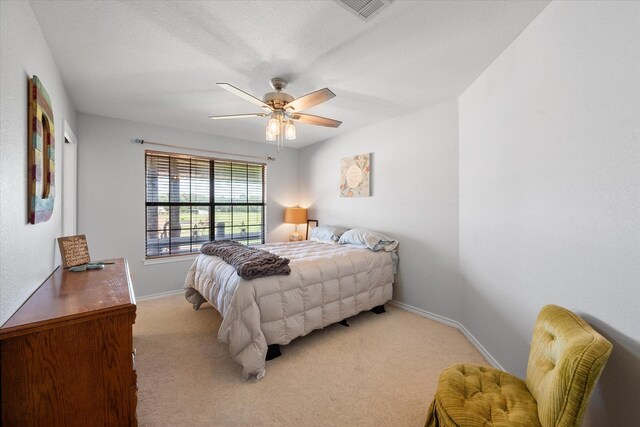 bedroom with ceiling fan and light carpet