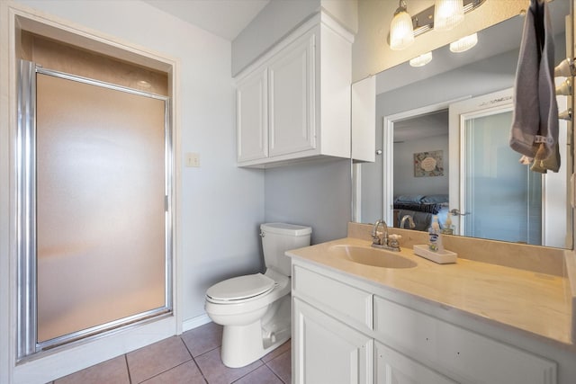 bathroom with toilet, vanity, tile patterned floors, and walk in shower