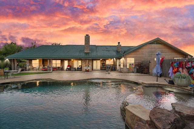 pool at dusk with a patio