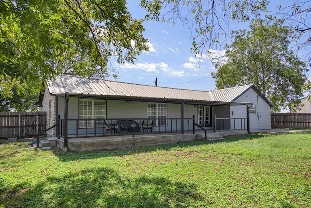 rear view of house featuring covered porch and a yard