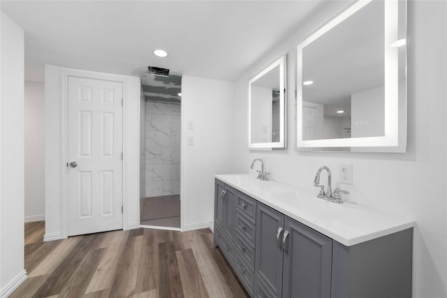 bathroom with oversized vanity, dual sinks, and hardwood / wood-style flooring