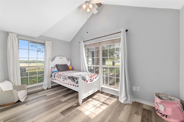 bedroom with ceiling fan, light hardwood / wood-style floors, and lofted ceiling