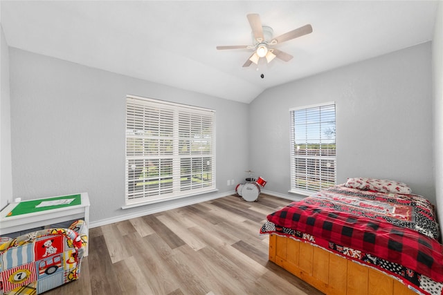 bedroom featuring ceiling fan, light hardwood / wood-style floors, and vaulted ceiling