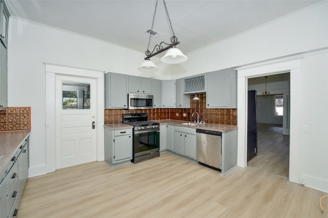 kitchen featuring a healthy amount of sunlight, sink, stainless steel appliances, and light hardwood / wood-style floors