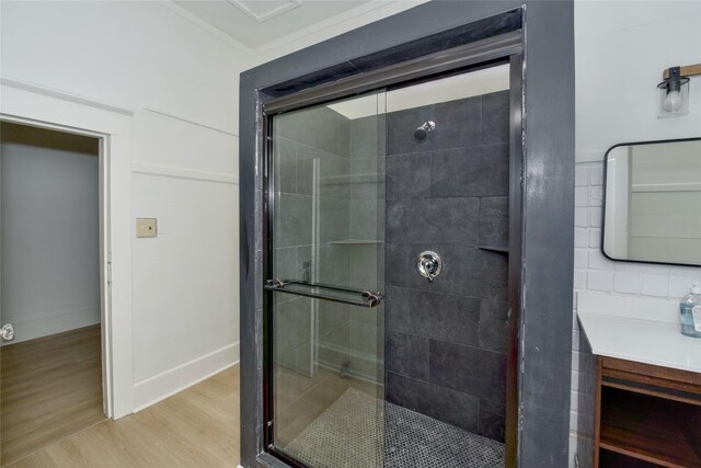 bathroom featuring hardwood / wood-style floors, vanity, an enclosed shower, and ornamental molding