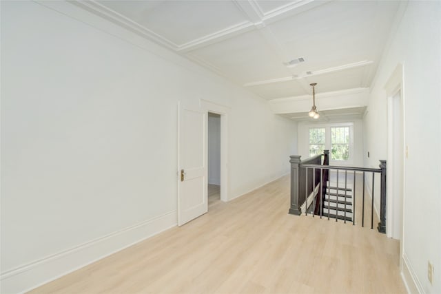 empty room featuring light hardwood / wood-style floors, beam ceiling, and coffered ceiling