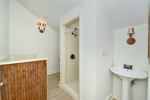 bathroom featuring a shower, hardwood / wood-style floors, and lofted ceiling