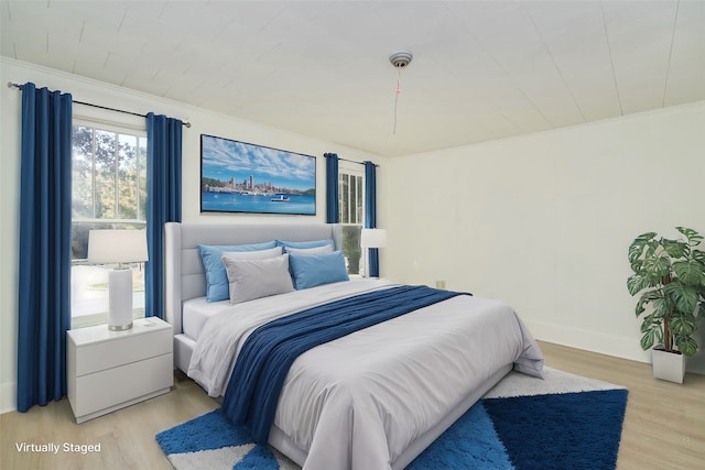 bedroom with crown molding and light hardwood / wood-style flooring