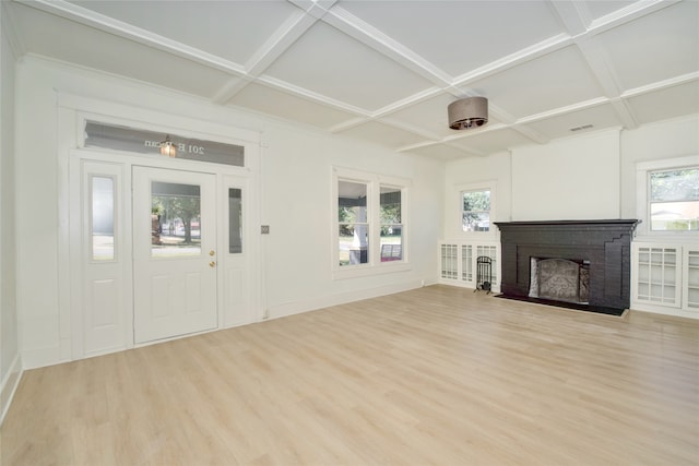 unfurnished living room featuring coffered ceiling, a fireplace, and light hardwood / wood-style flooring