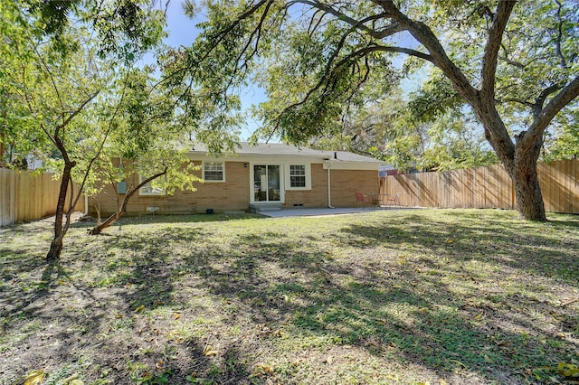 back of house featuring a patio and a lawn