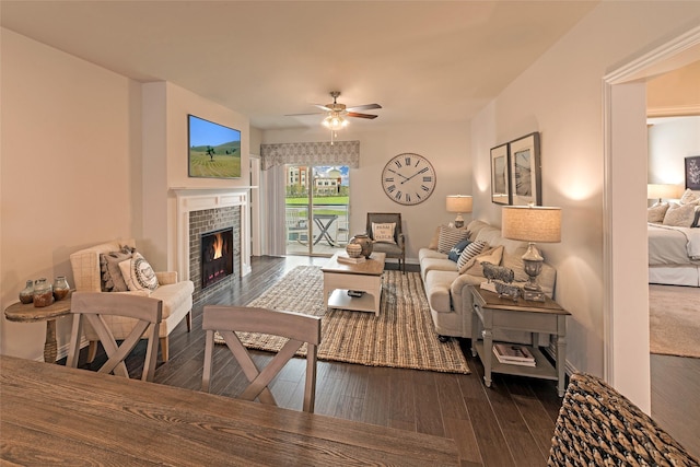 living room with ceiling fan, dark hardwood / wood-style floors, and a tile fireplace