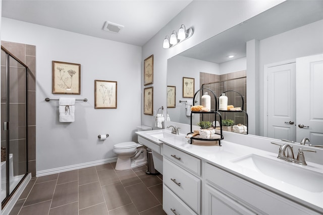 bathroom with vanity, toilet, and a shower with door