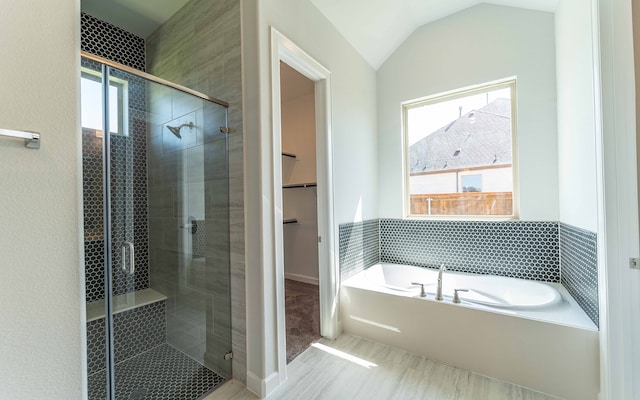 bathroom with lofted ceiling and plus walk in shower