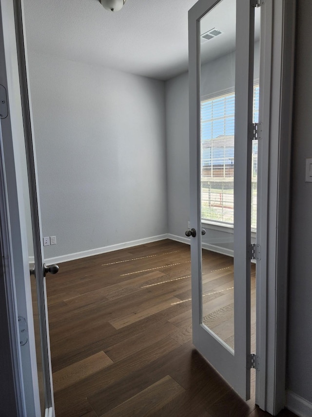 spare room with french doors and dark hardwood / wood-style floors