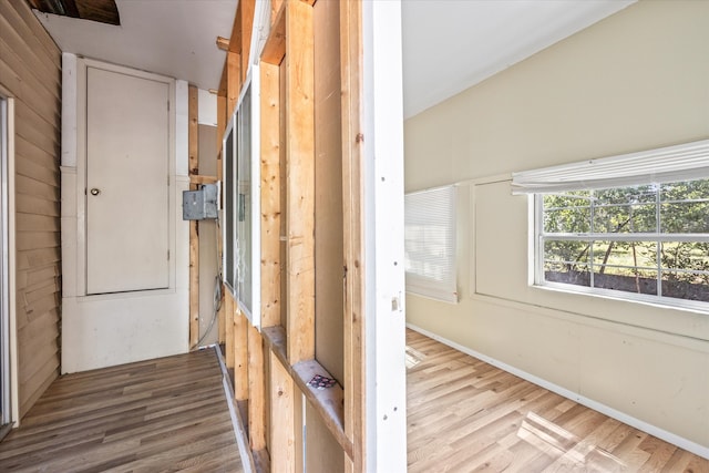 hallway featuring vaulted ceiling and light wood-type flooring