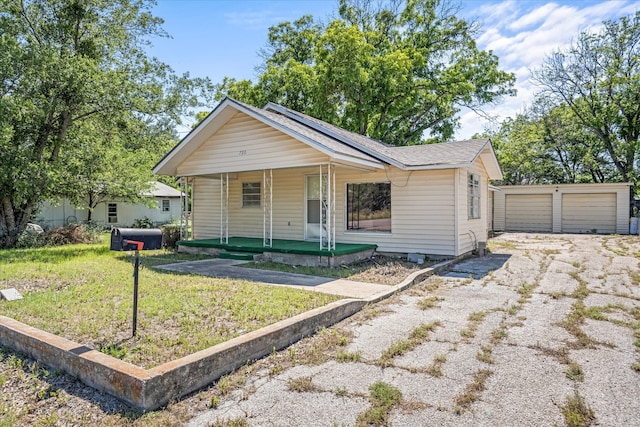 view of front of property featuring a front yard, an outdoor structure, and a garage