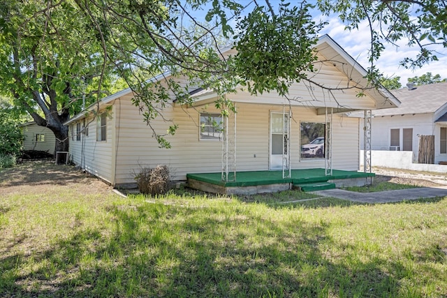 back of property with a porch and a yard