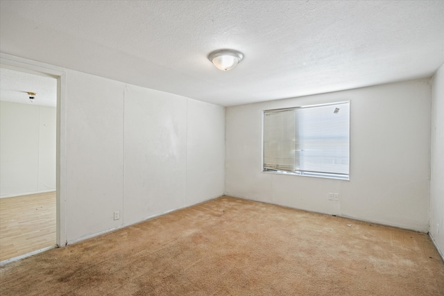 carpeted spare room with a textured ceiling