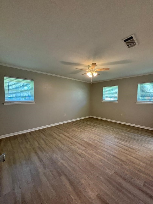 empty room with dark hardwood / wood-style flooring, ornamental molding, and ceiling fan