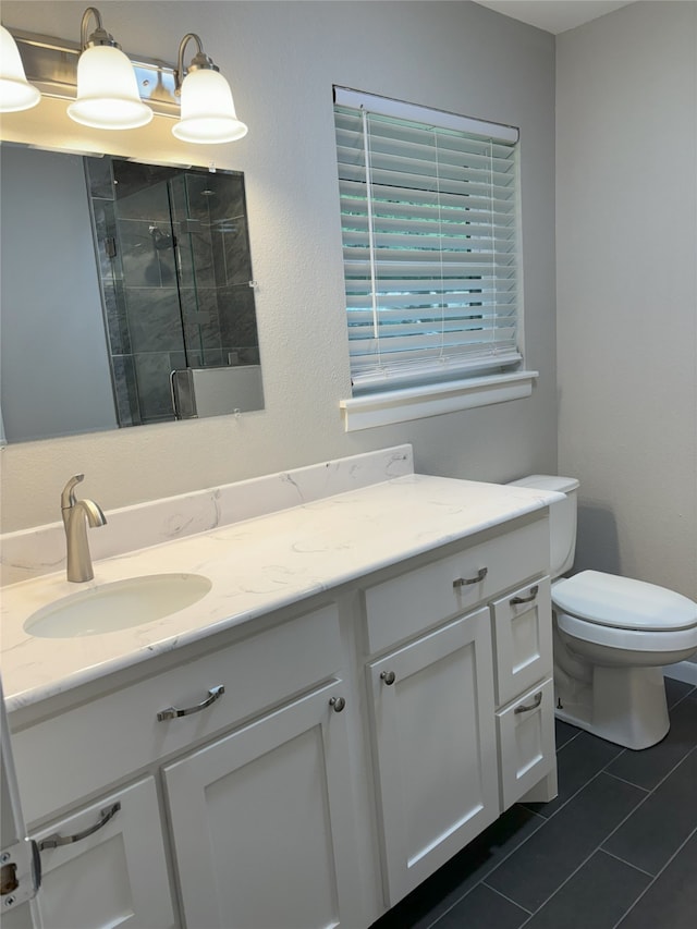 bathroom with tile floors, vanity, and toilet