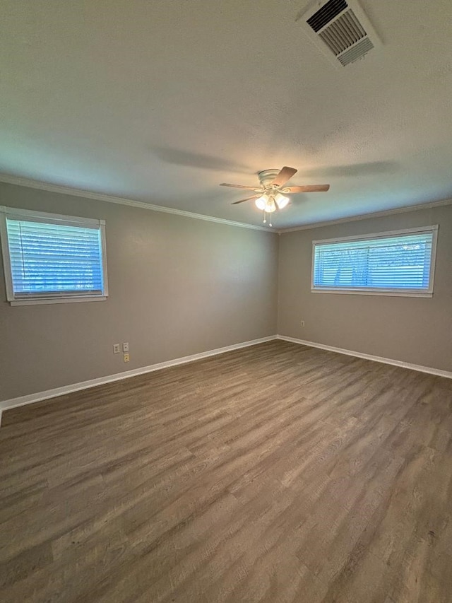 empty room featuring ceiling fan, crown molding, and hardwood / wood-style flooring