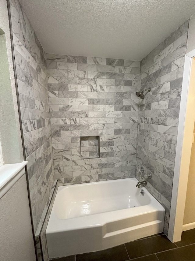 bathroom featuring tile flooring, a textured ceiling, and tiled shower / bath combo