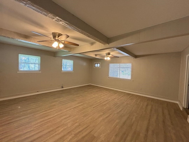 empty room with ceiling fan, beam ceiling, and wood-type flooring