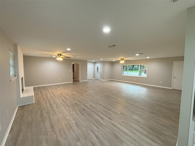 unfurnished living room with wood-type flooring and ceiling fan