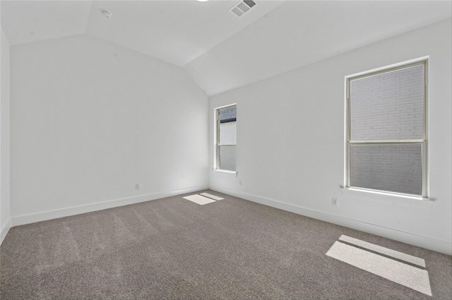 empty room with lofted ceiling and carpet