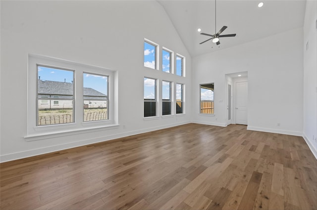 unfurnished living room featuring ceiling fan, high vaulted ceiling, and hardwood / wood-style flooring