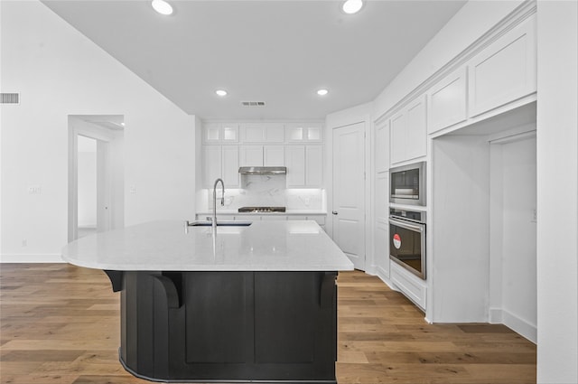 kitchen with appliances with stainless steel finishes, white cabinetry, and light hardwood / wood-style floors