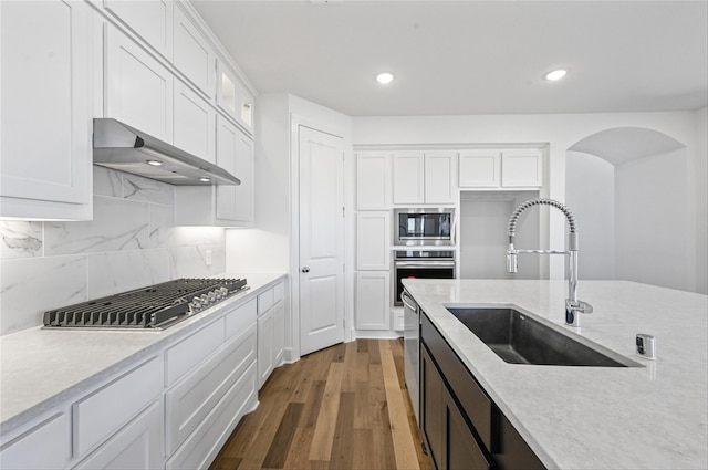 kitchen featuring sink, hardwood / wood-style floors, appliances with stainless steel finishes, and white cabinetry