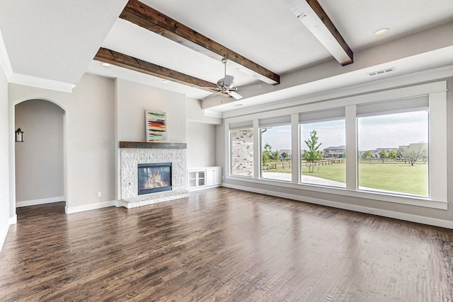 unfurnished living room with ceiling fan, beamed ceiling, and dark hardwood / wood-style floors