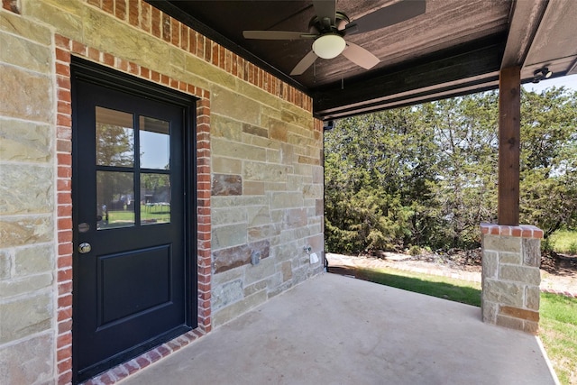 doorway to property featuring brick siding and ceiling fan