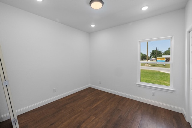 empty room with recessed lighting, dark wood-style floors, and baseboards