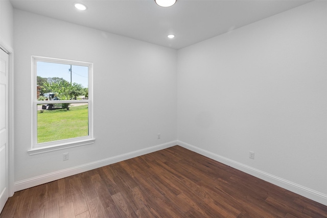 spare room with recessed lighting, baseboards, and dark wood-style flooring