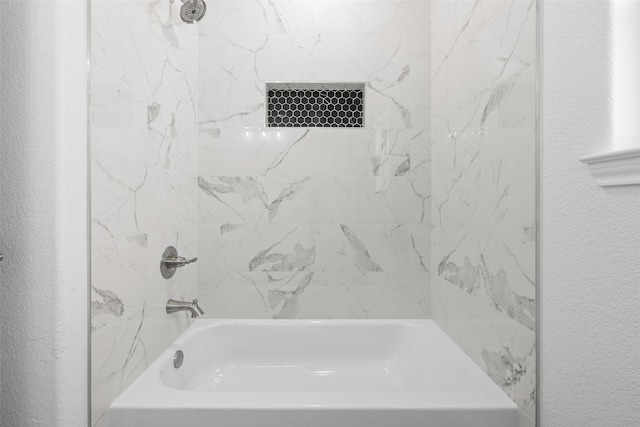 full bath featuring tub / shower combination and a textured wall